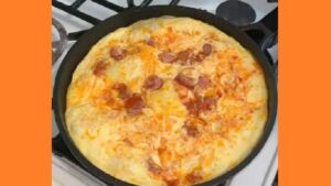 Омлет із сосисками на сковороді. Фото